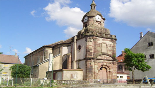 L'église Sainte-Croix et son clocher contre l'abside de Niderviller en Moselle